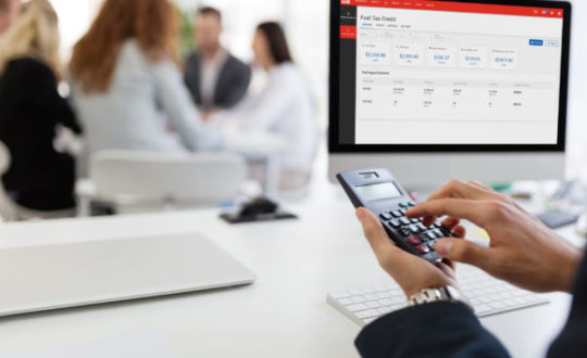 Picture of busy man using calculator in office