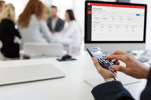 Picture of busy man using calculator in office